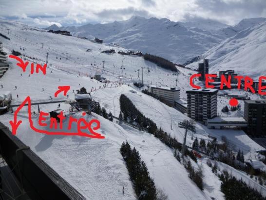a snow covered ski slope with people skiing on it at Studio Les Menuires Brelin in Les Menuires