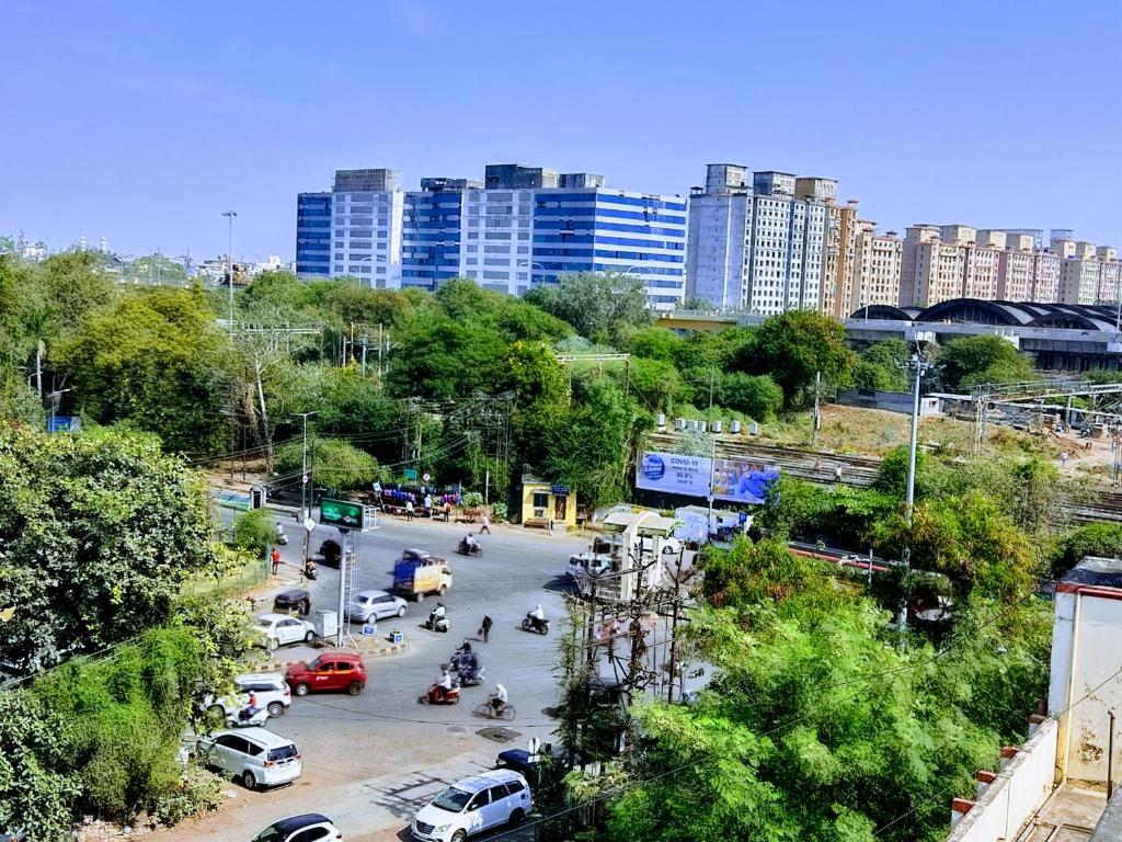 a city with cars parked in a parking lot with tall buildings at Raj Mahal Hotel in Nagpur