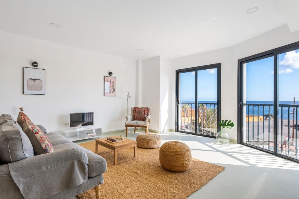 un soggiorno con divano e vista sull'oceano di Modern Design House with Roof Terrace a Poris de Abona