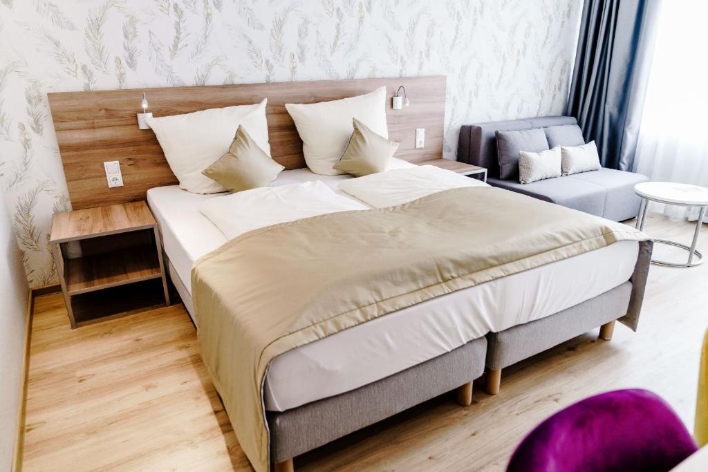 ein Schlafzimmer mit einem großen Bett und einem Stuhl in der Unterkunft Haus am See Luxury HS 949 B in Hahnenklee-Bockswiese