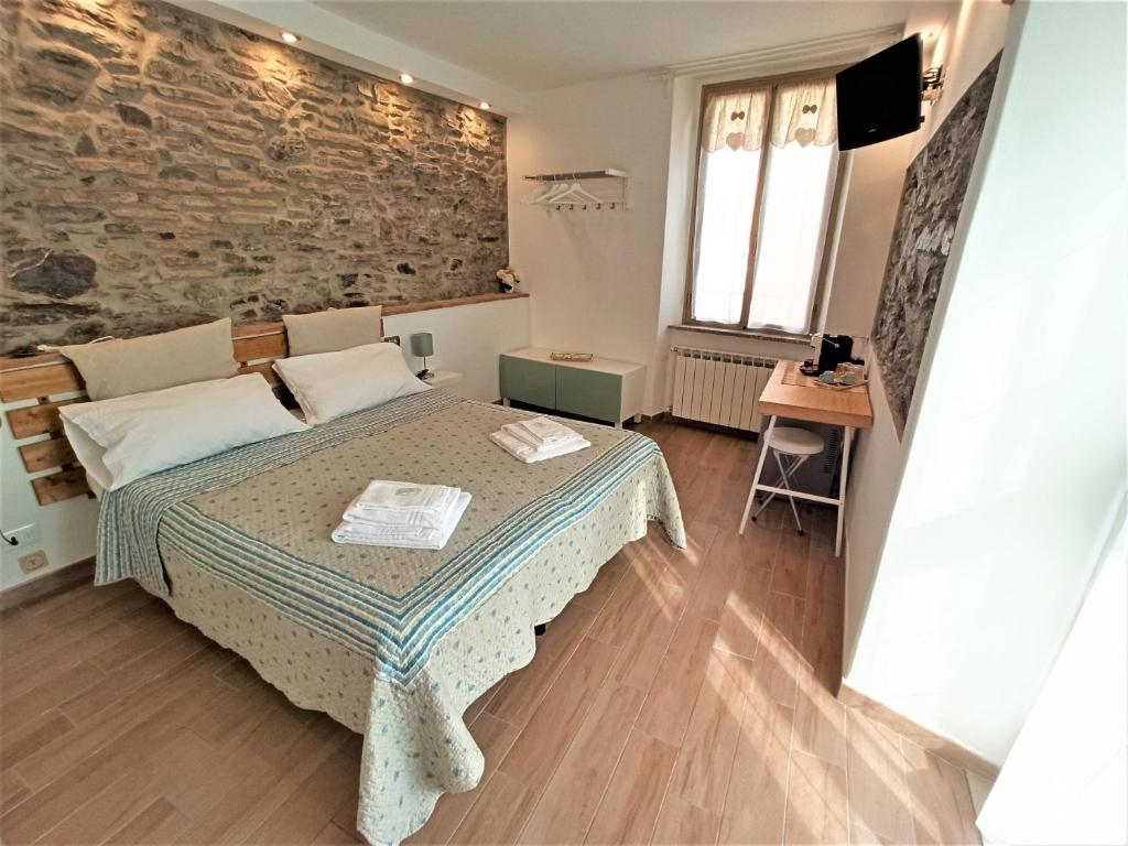 a bedroom with a bed and a brick wall at Affittacamere Albarola in Riomaggiore