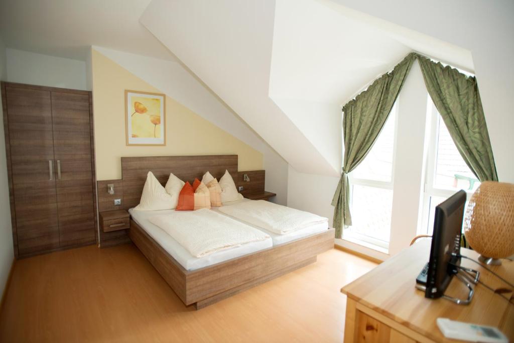 イルミッツにあるWeingut Apartment Hildegard Ganglのベッドルーム1室(ベッド1台、デスク、窓付)