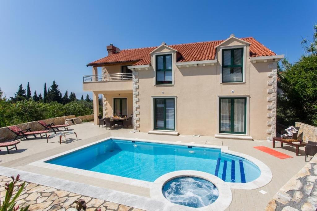 a villa with a swimming pool in front of a house at Villa Avoca in Mlini