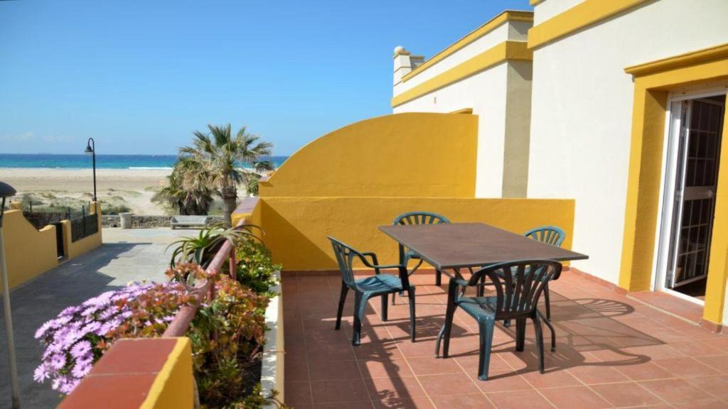 un patio con mesa y sillas y la playa en Apartamento Tortuga Carey, en Tarifa