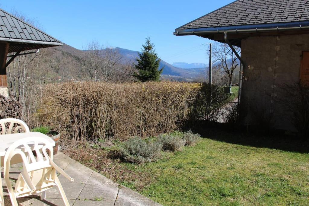 - deux chaises blanches assises sur une terrasse dans l'établissement Aux P'tioux Bonheurs, à Le Noyer