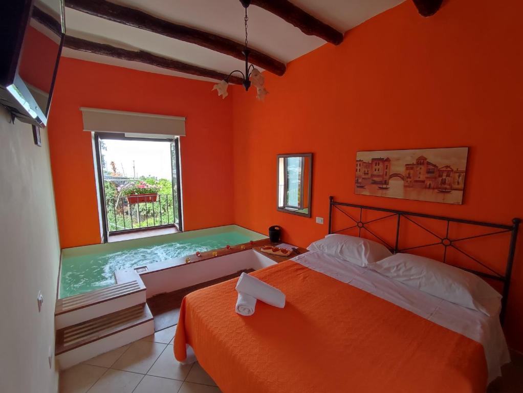- une chambre avec des murs orange, un lit et une fenêtre dans l'établissement Patrizia Casa Vacanze, à Sant'Agnello