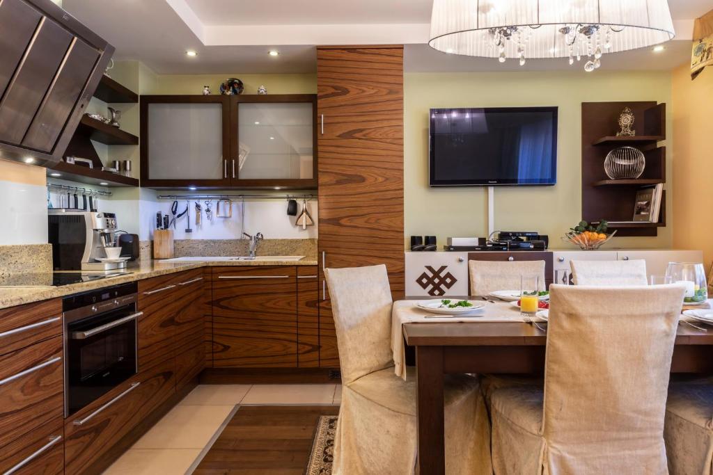 eine Küche mit Holzschränken und einem Tisch mit Stühlen in der Unterkunft Prestige II in Zakopane