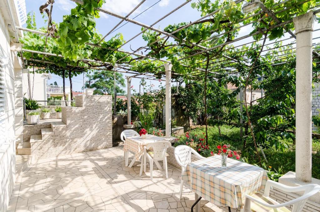 a patio with tables and chairs in a greenhouse at Katarina Rooms in Dubrovnik