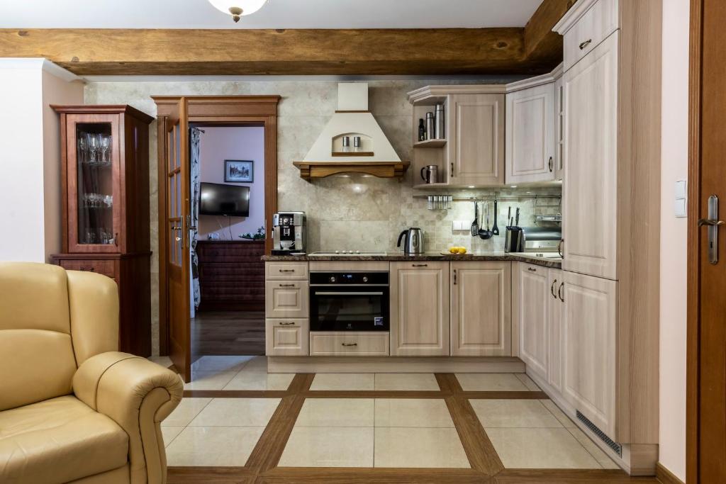 a kitchen with white cabinets and a couch at Portofino in Zakopane