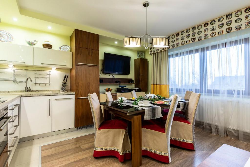 a kitchen and dining room with a table and chairs at Prestige in Zakopane