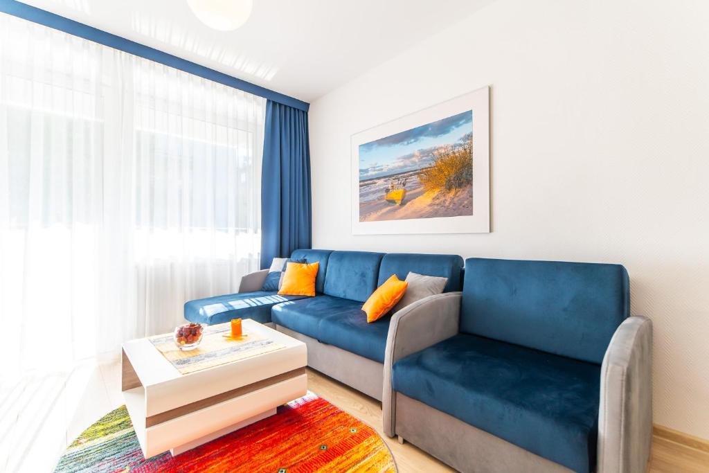 科沃布熱格的住宿－Apatrament u Ireny - Bliżej Morza，客厅配有蓝色的沙发和桌子