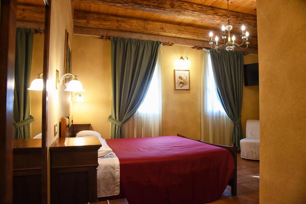 1 dormitorio con cama roja y espejo en Agriturismo Corte Benetti, en Rovigo