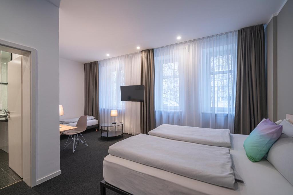 ein Hotelzimmer mit 2 Betten und einem Schreibtisch in der Unterkunft BIG MAMA Leipzig in Leipzig
