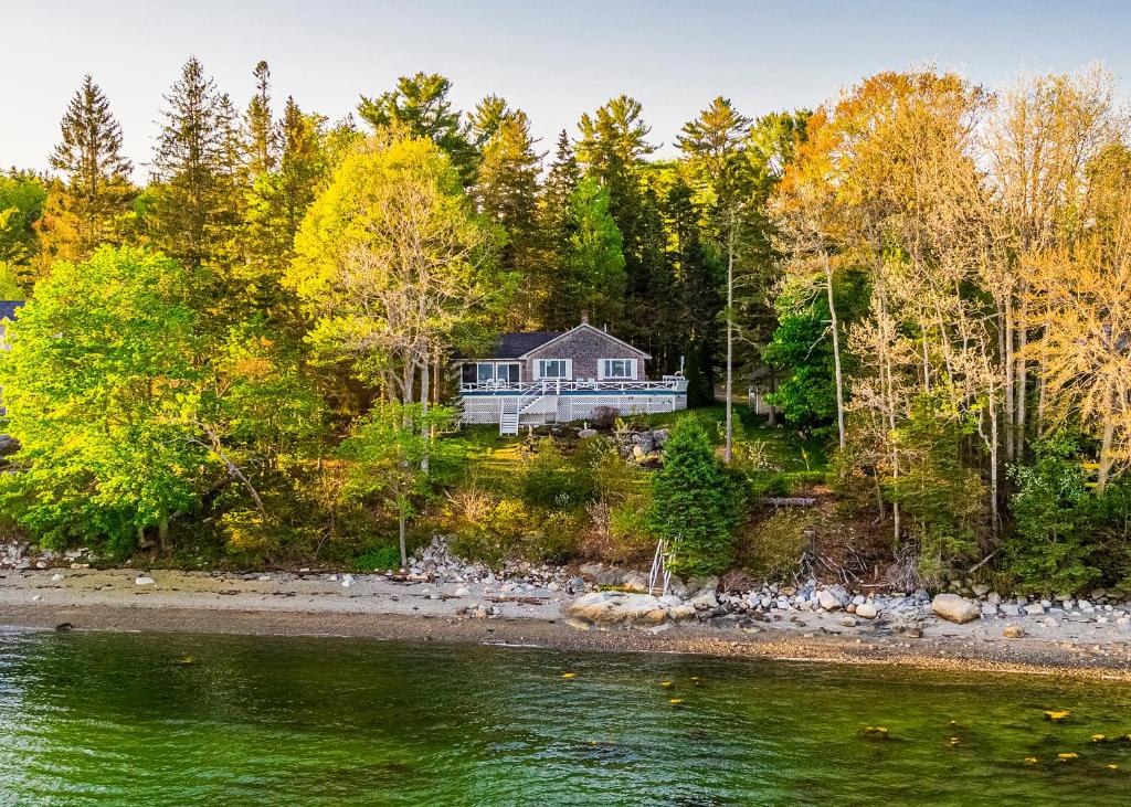 a house on the shore of a body of water at Lucky Stone Retreat - private beach & Acadia view in Sullivan
