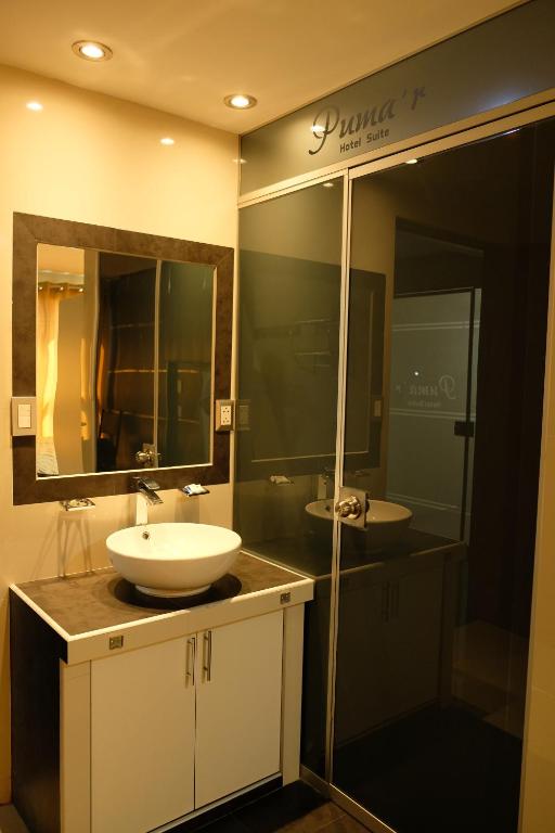 a bathroom with two sinks and a large mirror at Hotel Puma'r Tacna in Tacna