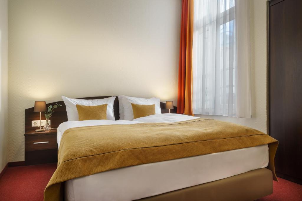 - une chambre avec un grand lit et une fenêtre dans l'établissement Novum Hotel Eleazar City Center, à Hambourg