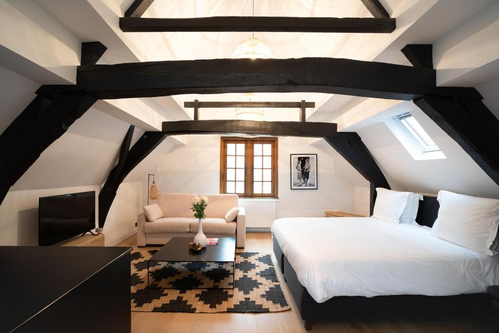 a bedroom with a bed and a couch and a table at Smartflats - Grand-Place II in Brussels