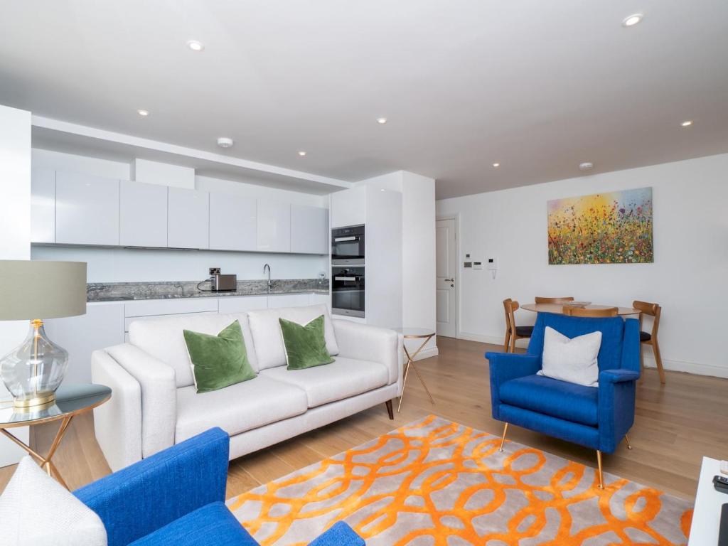 ein Wohnzimmer mit einem weißen Sofa und blauen Stühlen in der Unterkunft Pass The Keys Quiet 1 bed central apartment with parking in Bath