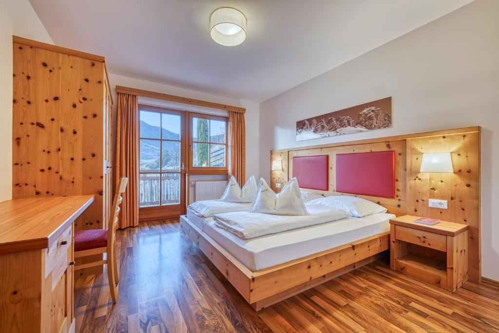 a bedroom with a large bed with a wooden headboard at Appartements Riegelehof in Laion
