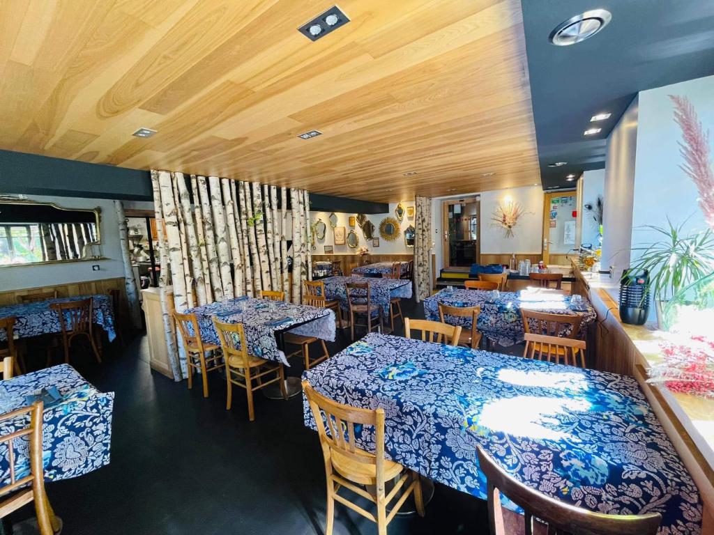 a restaurant with tables and chairs with blue table cloth at Hôtel Restaurant "La Petite Auberge" in Bourg-Saint-Maurice