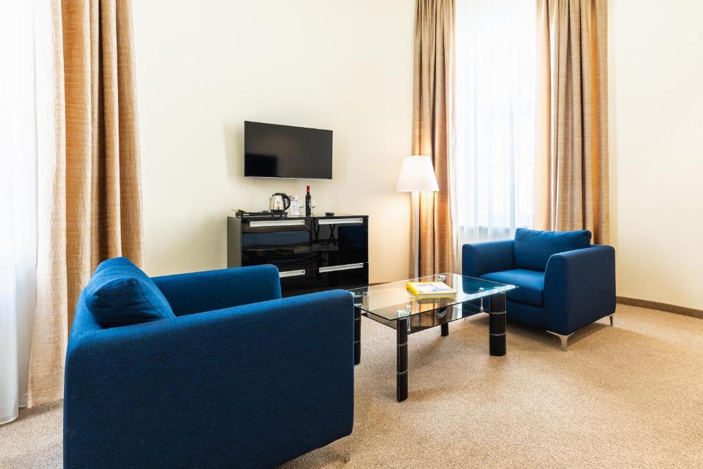 Televízia a/alebo spoločenská miestnosť v ubytovaní HiLight Suites Hotel