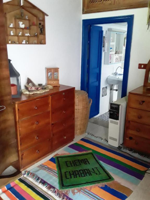 a living room with a dresser and a rug at Maison d'hôte Chama in Kairouan