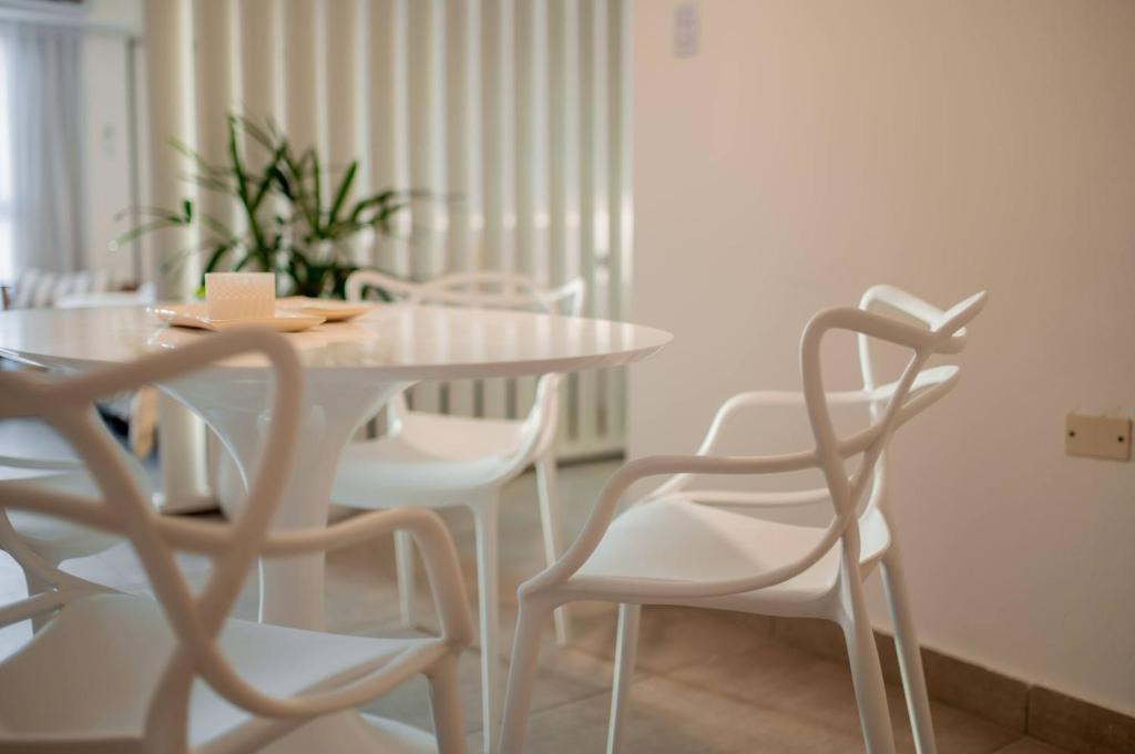 a dining room with a white table and white chairs at Decom Suites in La Rioja