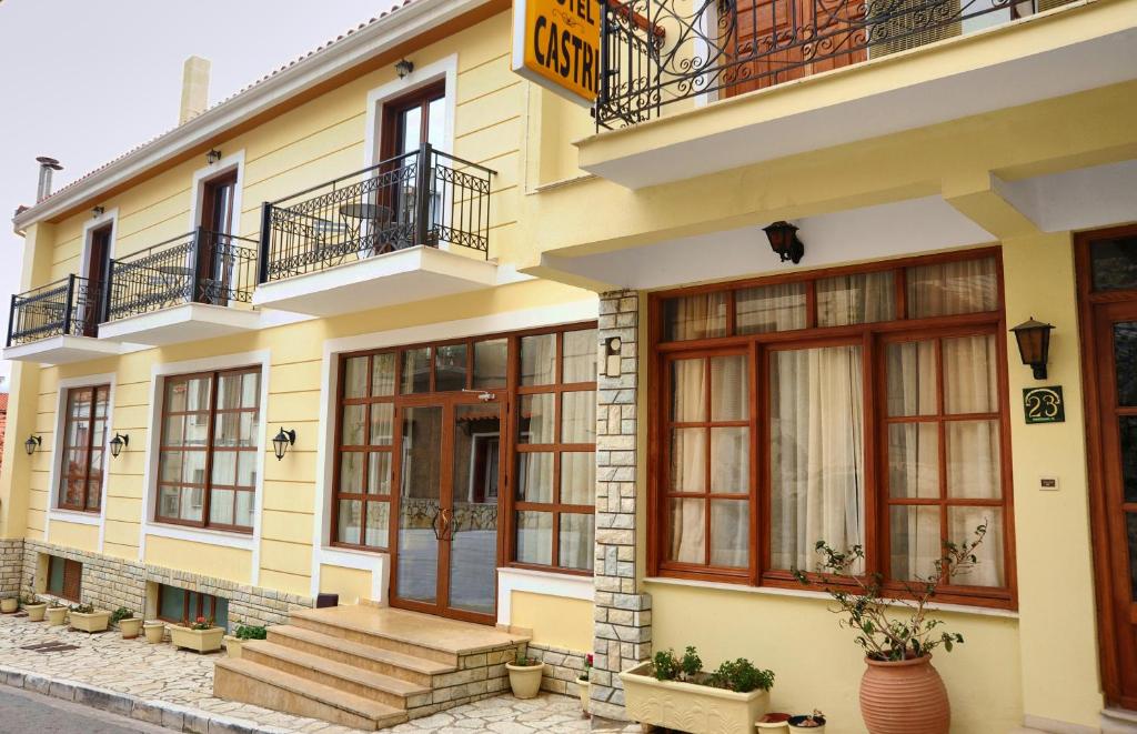 um edifício amarelo com escadas e janelas em Castri Hotel em Delfoi