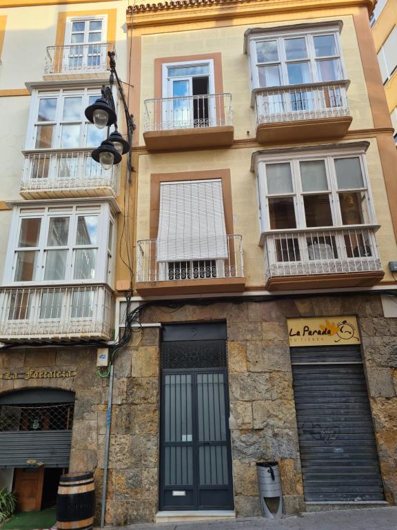 um edifício com janelas e varandas numa rua em LOS BALCONES DE LA CALLE CAÑON em Cartagena