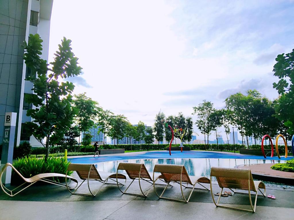 een zwembad met stoelen en een speeltuin bij Maxine Suites in Kuala Lumpur