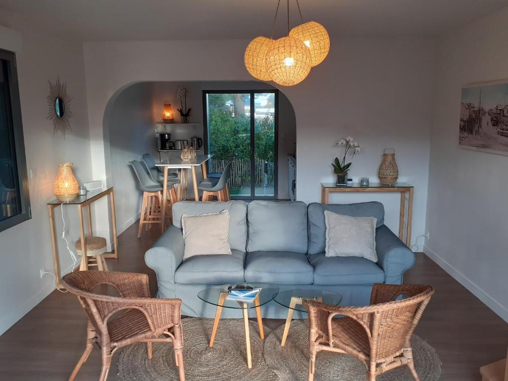- un salon avec un canapé bleu et des chaises dans l&#39;établissement Villa Jules Grand Gîte, à Agon-Coutainville