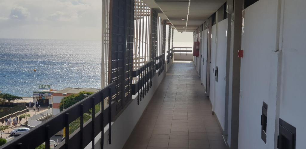 a corridor of a building with a view of the ocean at Playa del Ingles. Apartamento al lado del océano in San Bartolomé de Tirajana