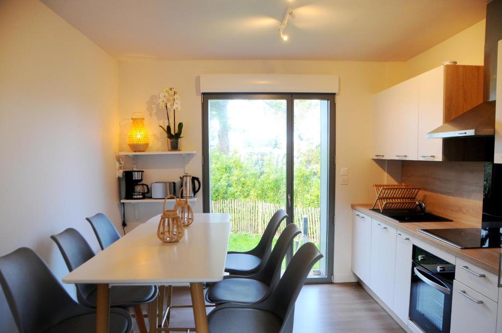 - une cuisine avec une table et des chaises dans la chambre dans l&#39;établissement Villa Jules Grand Gîte, à Agon-Coutainville