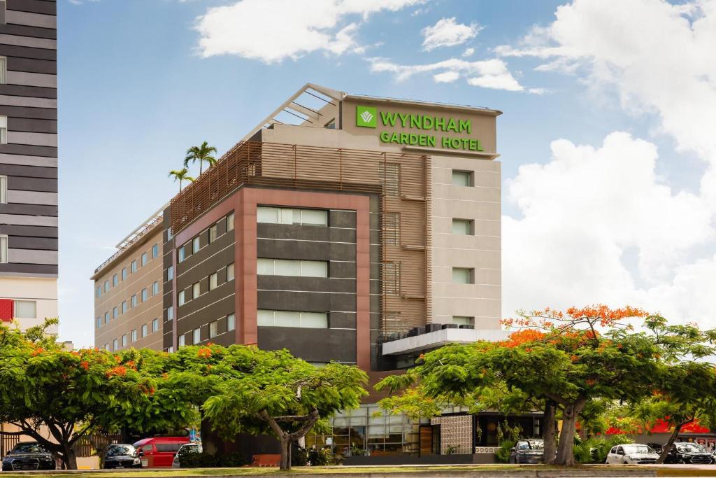 un bâtiment avec un panneau indiquant un hôtel avec jardin waughkin dans l'établissement Wyndham Garden Cancun Downtown, à Cancún