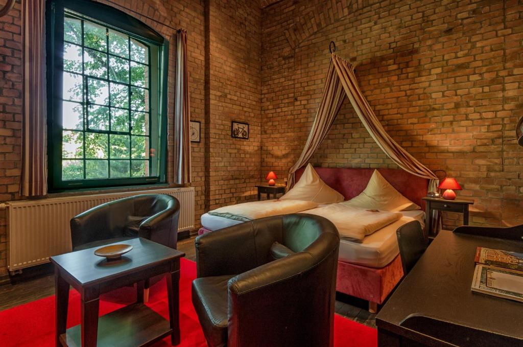 ein Schlafzimmer mit einem Bett und Stühlen in einem Zimmer in der Unterkunft Hotel zur Henne in Naumburg