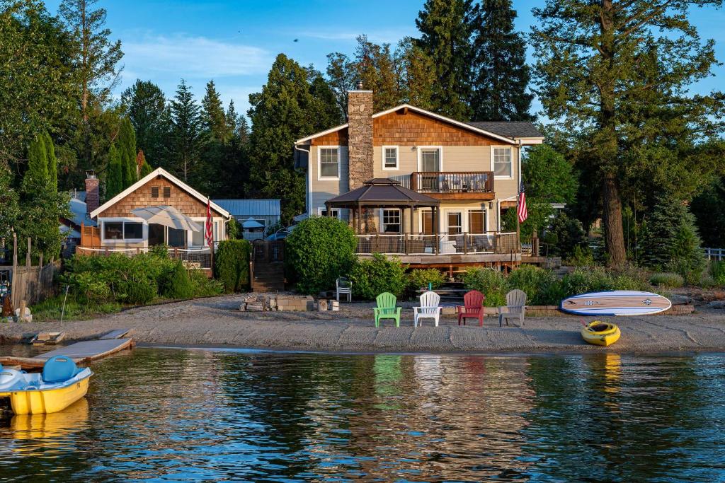 una casa en la orilla del agua con sillas en Charming Lakefront Cabin with Deck and Fire Pit!, en Newport