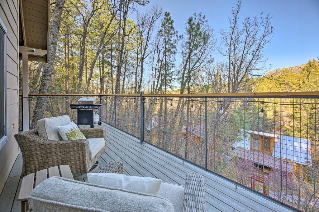 a balcony with a couch and chairs on a deck at Cabin 404 - Payson Getaway with Deck and Mtn Views! in Payson