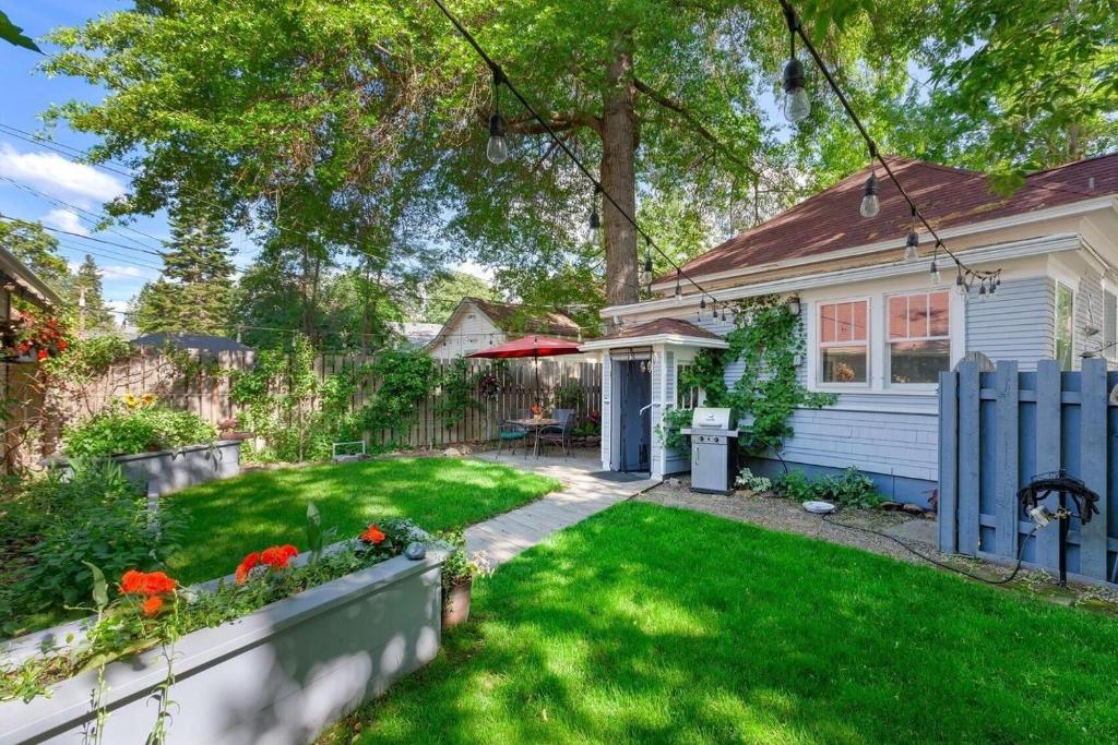 a home with a yard with a blue fence at Whimsical Coeur dAlene Escape, Walk to Beach! in Coeur d'Alene