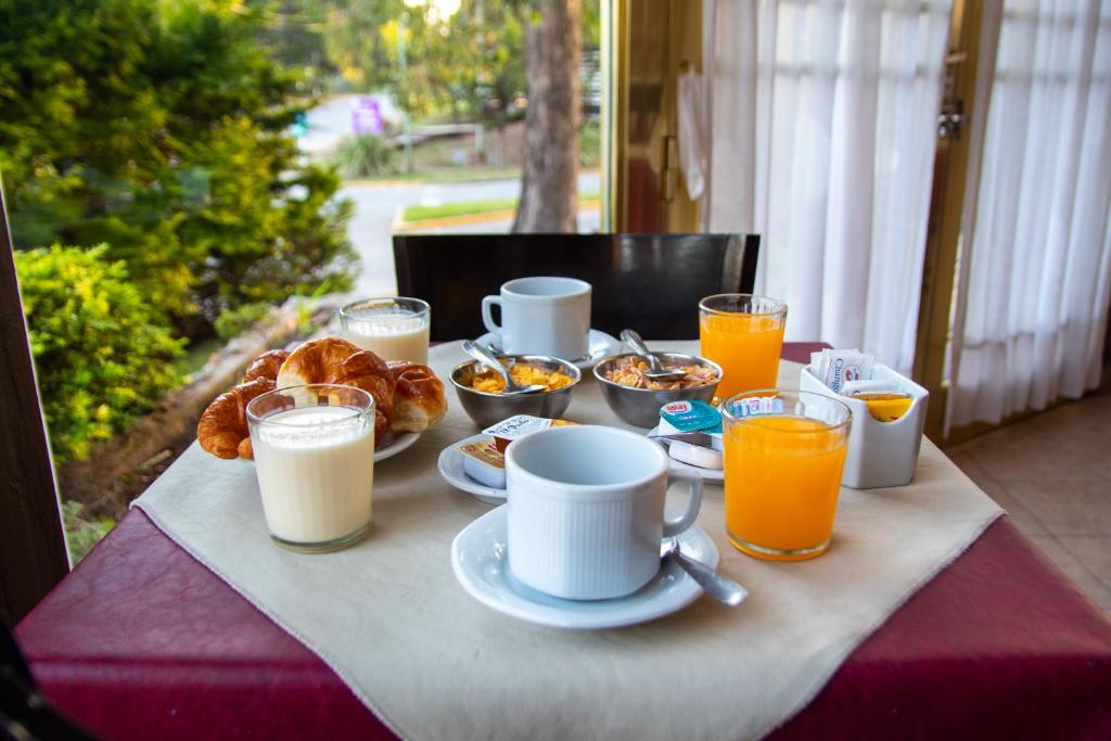 una mesa con desayuno y tazas de zumo de naranja en Piedras Doradas Hotel y Spa en Valeria del Mar