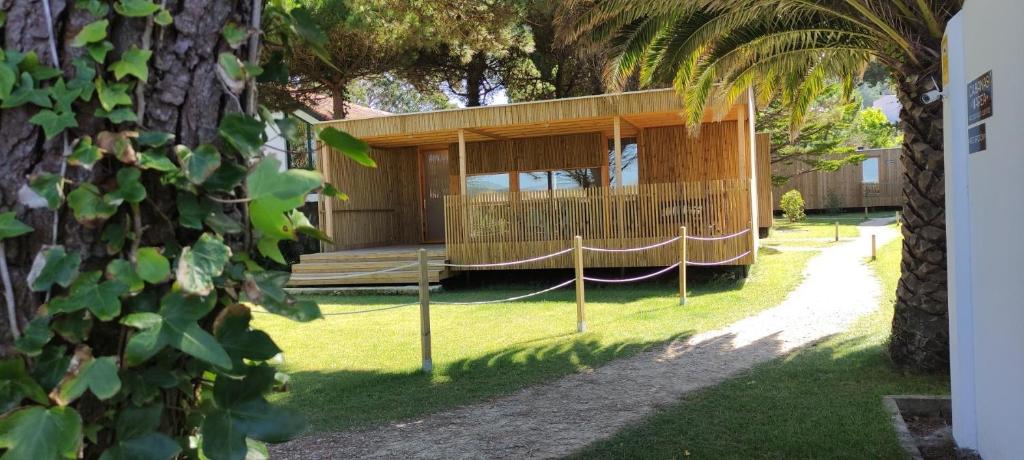 une maison avec un hamac dans une cour dans l'établissement Cabanas Narea, à Laxe