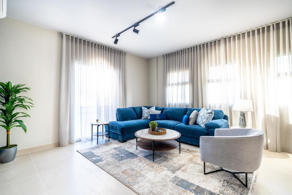 a living room with a blue couch and a table at Mabaat - Al Waha 5 - 243 in King Abdullah Economic City