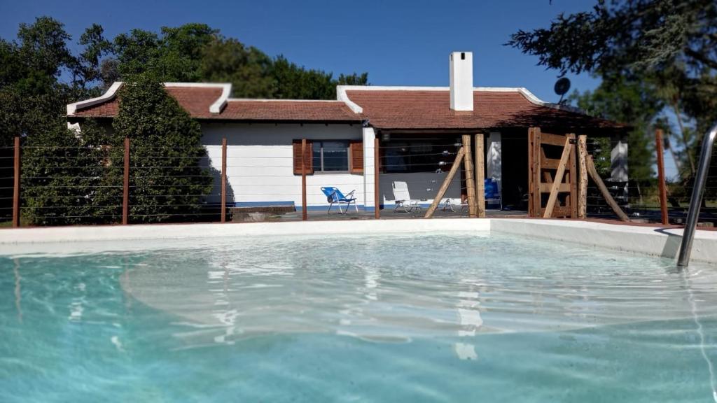 uma piscina de água em frente a uma casa em Casa de campo SONIANDO em Chivilcoy