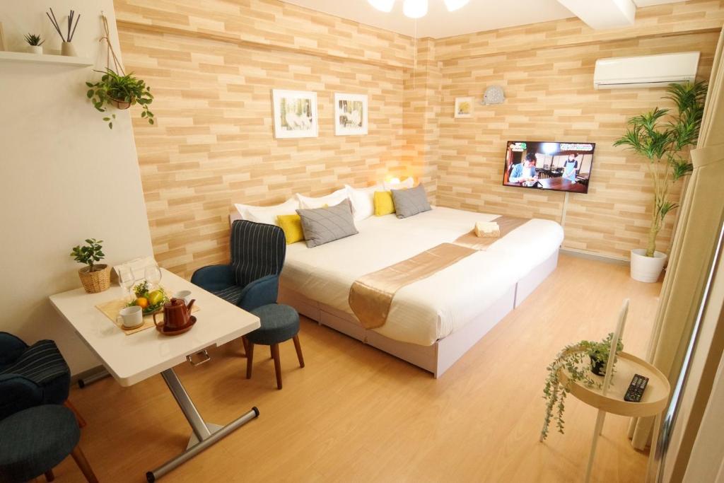 een slaapkamer met een bed en een tafel en een televisie bij Matsuyamachi Shimanouchi Building - Vacation STAY 12324 in Osaka
