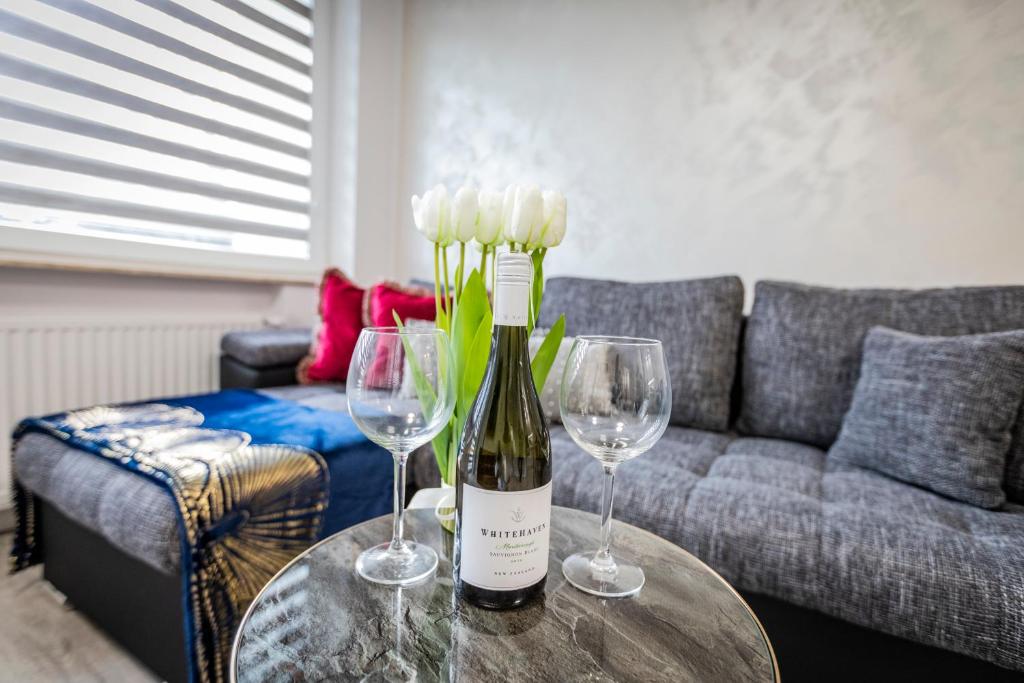 a bottle of wine on a table with two wine glasses at GDAŃSK CENTRUM Stylowy Apartament in Gdańsk