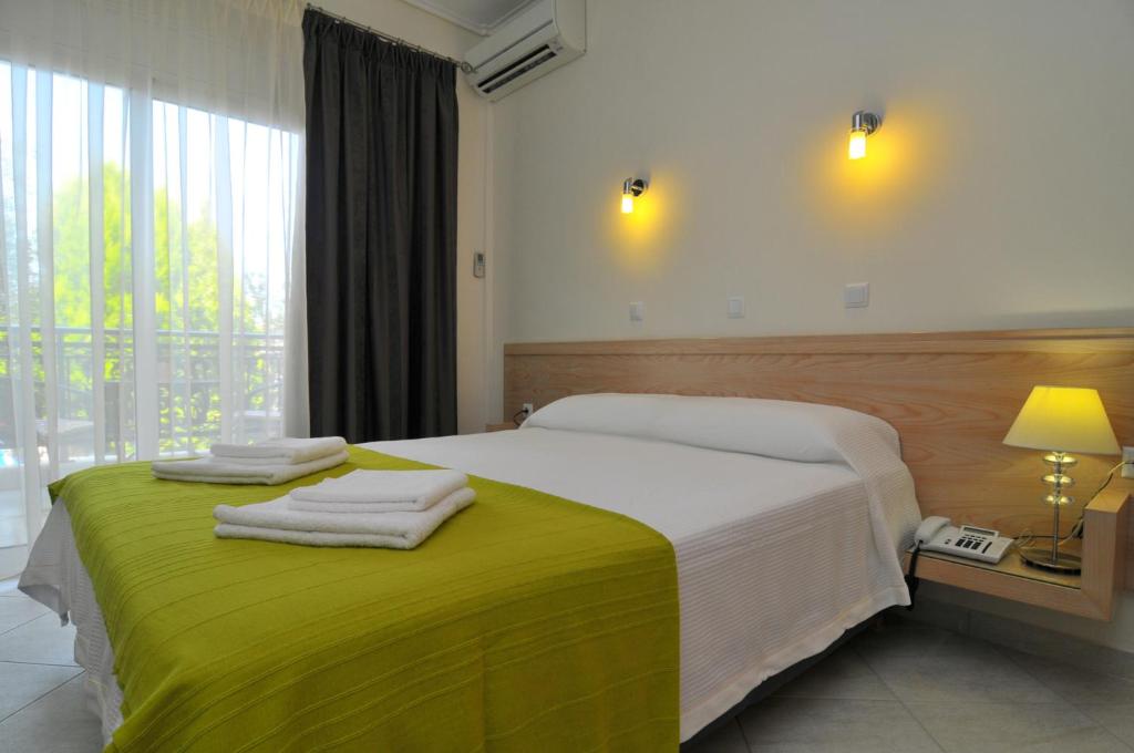 een slaapkamer met een groot bed en handdoeken bij Erodios Studios in Skala Kallirakhis