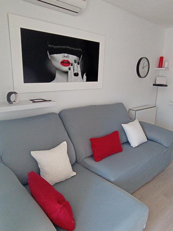 un soggiorno con divano blu e cuscini rossi di Apartamento El Príncipe a Peñíscola