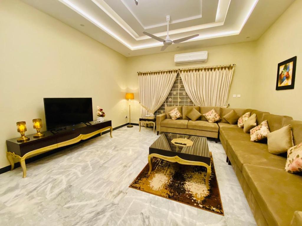 a living room with a couch and a tv at Homey Islamabad in Islamabad