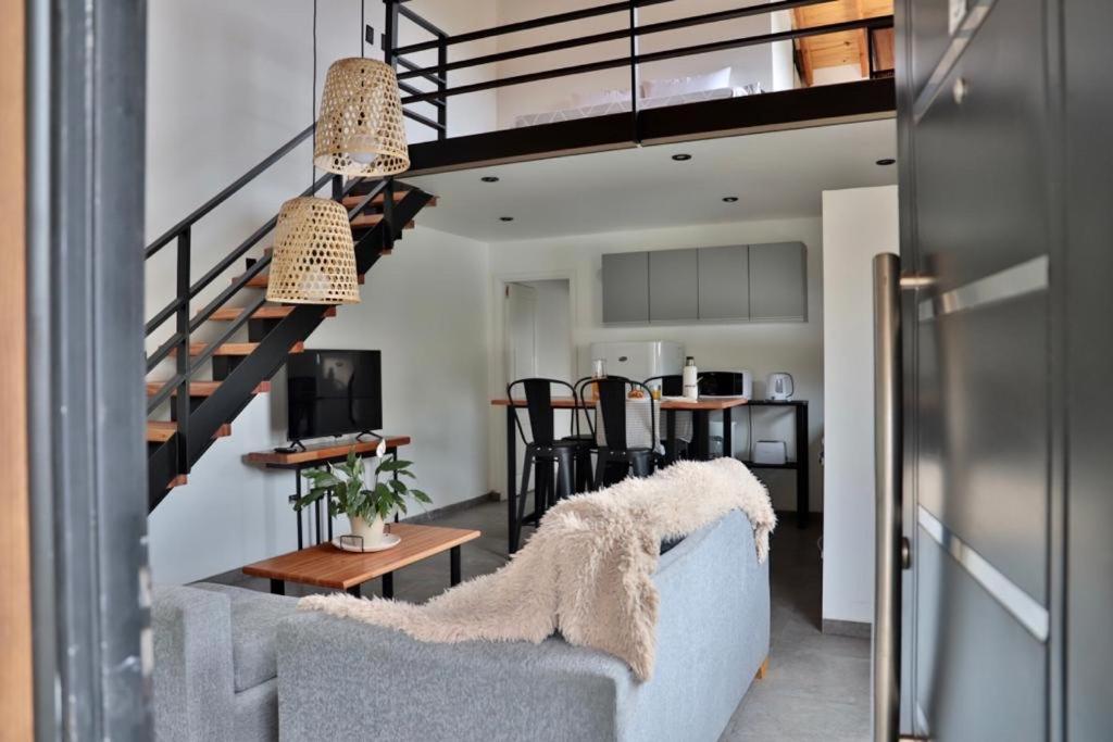 Una sala de estar con un sofá y una escalera. en Espino Blanco Apartamentos, en San Carlos de Bariloche