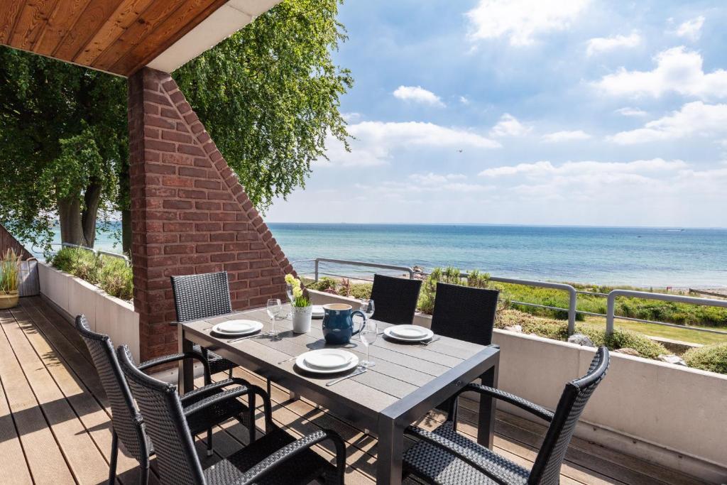 una mesa y sillas en un balcón con vistas al océano en Dream BIg Strandsuite en Rettin