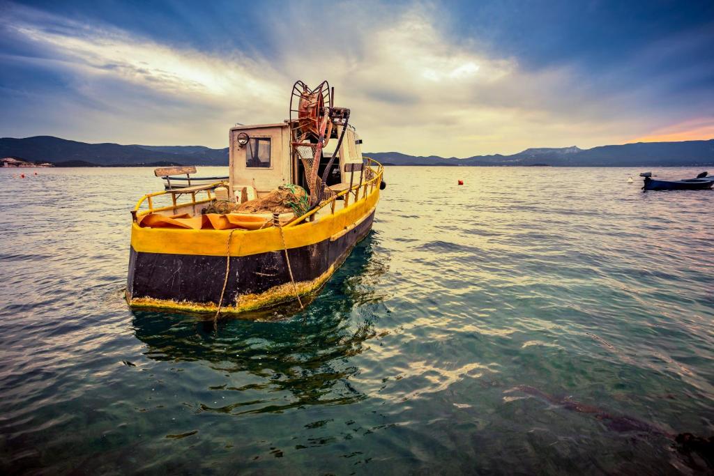 un barco amarillo sentado en el agua en Holiday Home, en Komarna